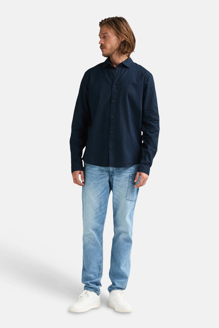 Blauw overhemd met lange mouwen van Petrol Industries®, gedragen met jeans en witte sneakers.
