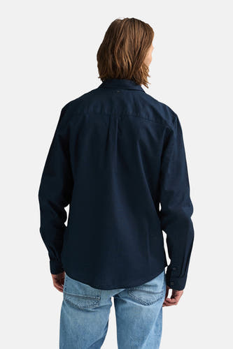 Blauw hemd van Petrol Industries met lange mouwen, gezien van achteren, gedragen met een jeans.