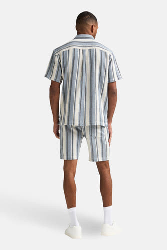 Blauw gestreept overhemd met korte mouwen van Petrol Industries®, achterkant, gecombineerd met bijpassende short en witte sneakers.