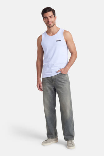 Blauwe tanktop van Petrol Industries, gedragen met een jeans en grijze sneakers.