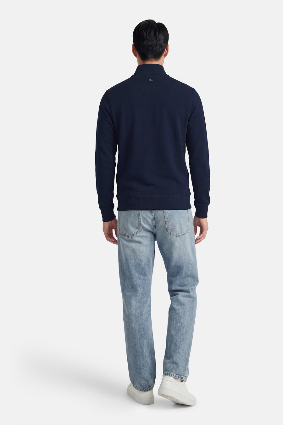 Blauwe sweater met ronde hals van Petrol Industries, gezien van achteren, met lichtblauwe jeans en witte sneakers.
