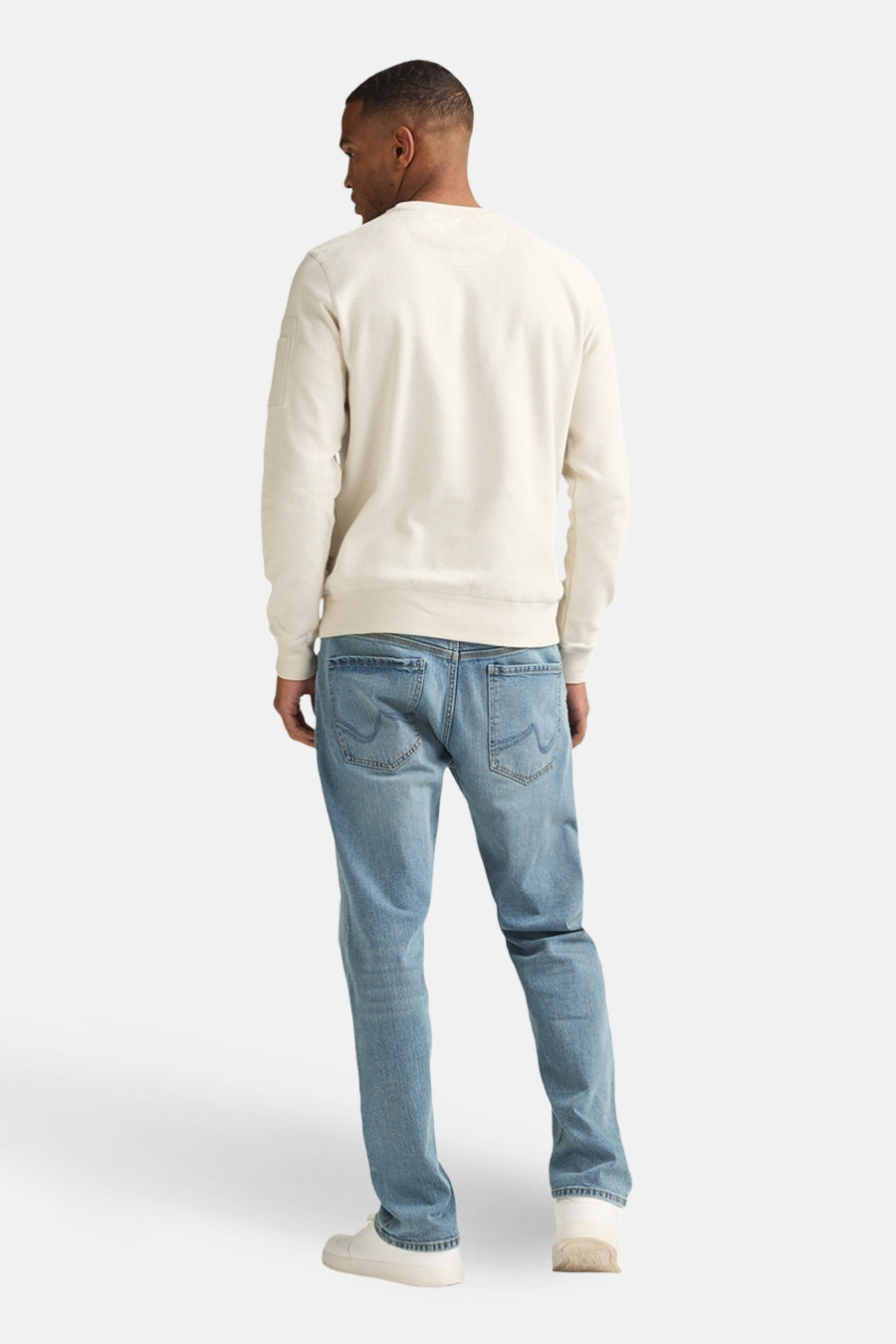 Ecrukleurige sweater met ronde hals van Petrol Industries, rugaanzicht, gecombineerd met jeans en witte sneakers.