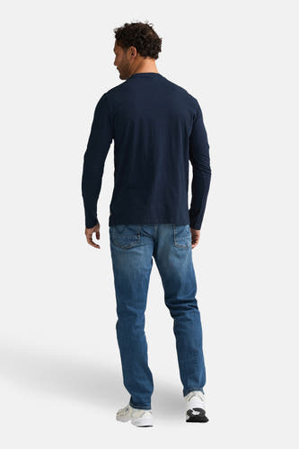 Blauw T-shirt met lange mouwen van Petrol Industries®, gezien van achteren, gecombineerd met blauwe jeans en witte sneakers.
