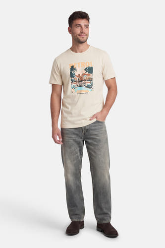 Ecru T-shirt met korte mouwen van Petrol Industries®, met een grafische print op de voorkant en gedragen met grijze jeans en bruine schoenen.

