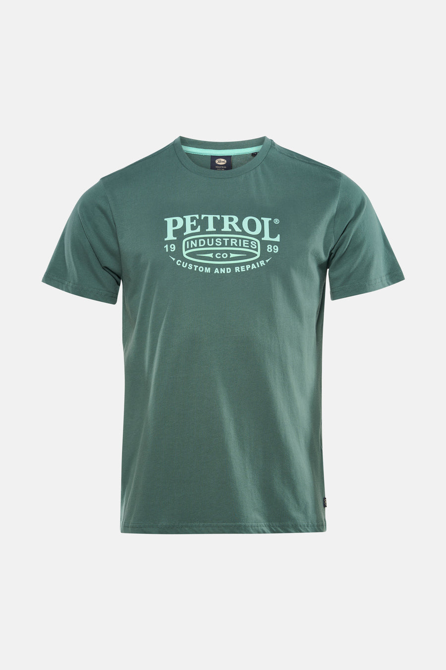 T-shirt vert à manches courtes de Petrol Industries, porté avec un jean foncé et des chaussures grises.
