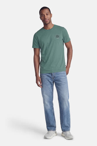 Groen T-shirt met korte mouwen van Petrol Industries®, met een kleine grafische print op de borst en gedragen met jeans.
