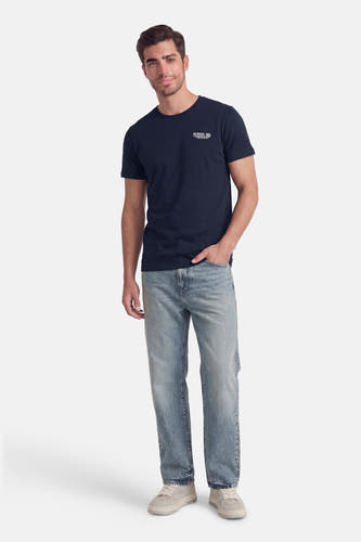 Blauw T-shirt met korte mouwen van Petrol Industries, met een kleine opdruk op de borst, gecombineerd met jeans en witte sneakers.