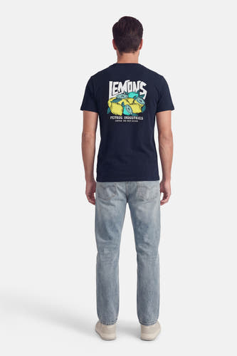 Blauw T-shirt met korte mouwen van Petrol Industries, met print van citroenen op de rug, gecombineerd met jeans en sneakers.
