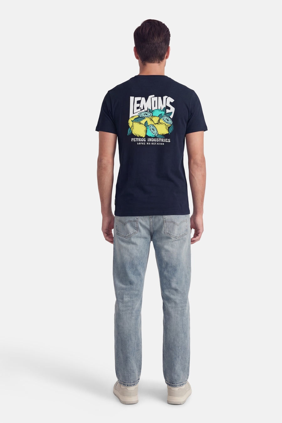 Blauw T-shirt met korte mouwen van Petrol Industries, met print van citroenen op de rug, gecombineerd met jeans en sneakers.
