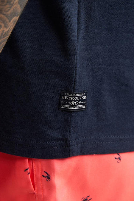 Débardeur bleu de Petrol Industries avec étiquette de marque noire et short orange à imprimé scorpion.