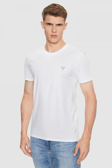 Wit T-shirt met korte mouwen van Guess met een klein logo op de borst, gedragen met een spijkerbroek.
