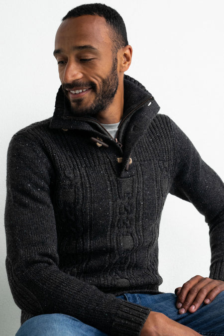 Pull gris de Petrol Industries, avec motif torsadé et col zippé, porté sur une chemise grise et un jean bleu.