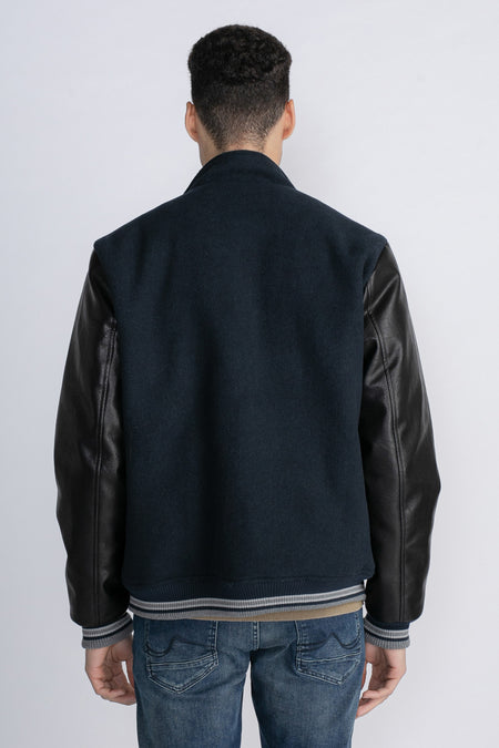 Jackeau bleu de Petrol Industries, avec des manches en cuir et des détails rayés, vu par derrière.