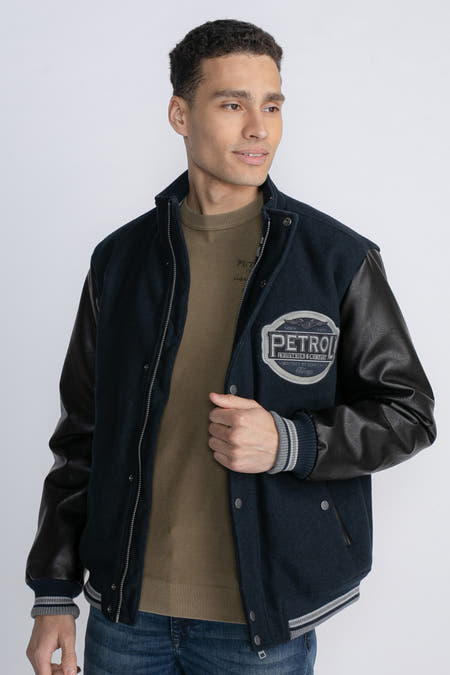 Blauwe korte jas van Petrol Industries met zwarte mouwen en een opgenaaid logo.
