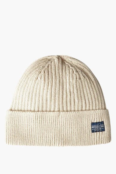 Beige gebreide muts van Petrol Industries, met ribbels en een blauw logolabel op de omslag.
