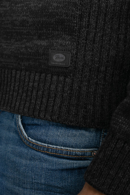 Pull en maille noire foncée à col rond de Petrol Industries®, bord-côte, texture et étiquette sur la poitrine, porté avec un jean bleu