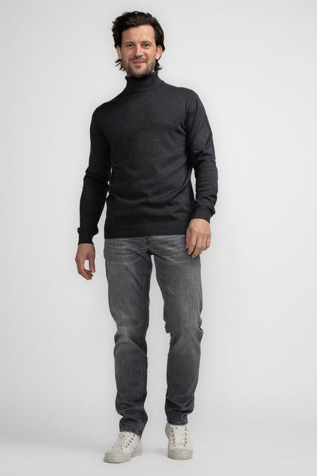 Blauwe coltrui van Petrol Industries®, gecombineerd met grijze jeans en witte sneakers.