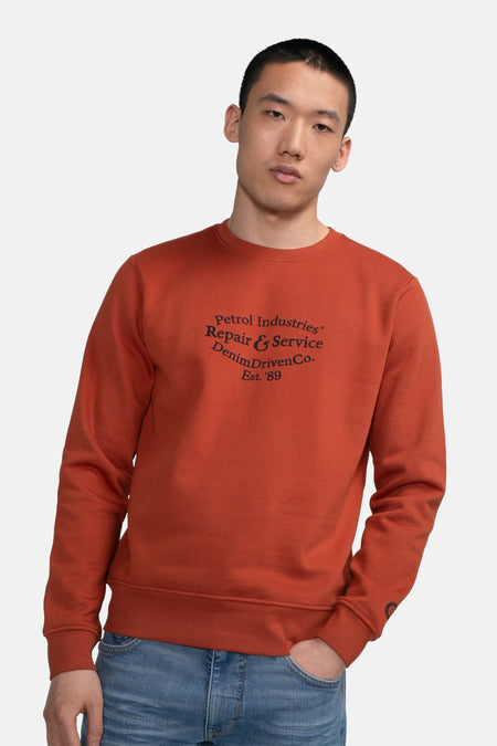 Gilet rouge de Petrol Industries avec un col rond et un texte imprimé sur la poitrine.
