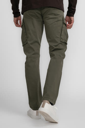 Pantalon de travail vert de Petrol Industries avec des poches et des baskets blanches.