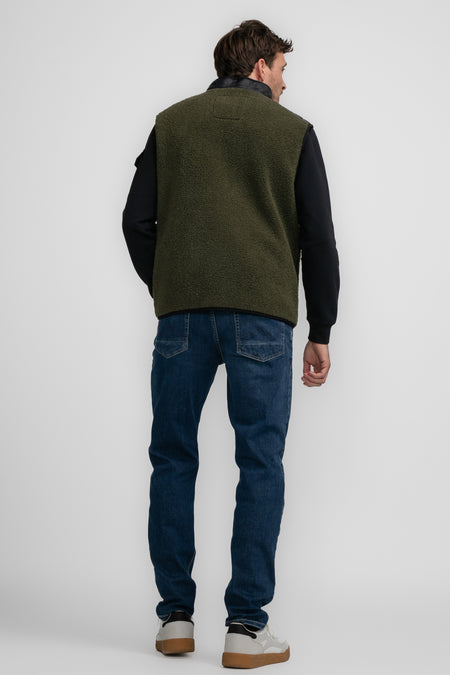 Groene bodywarmer van Petrol Industries met een zachte textuur, gedragen over een zwart shirt en donkere jeans.