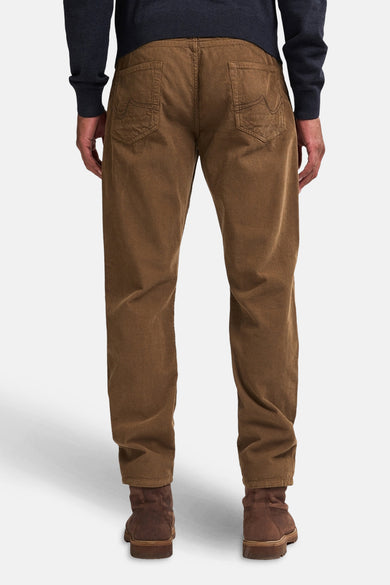 Pantalon beige de Petrol Industries, vu d'arrière, avec des chaussures marrons et une chemise bleu foncé.