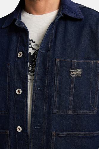 Blauw jeansjack van Petrol Industries met opgestikte zakken en zichtbare knoopsluiting.
