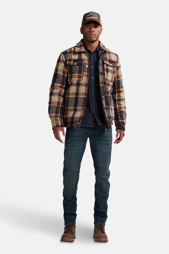 Korte multicolor jas van Petrol Industries, met een ruitpatroon, boven een donkerblauw overhemd en jeans.