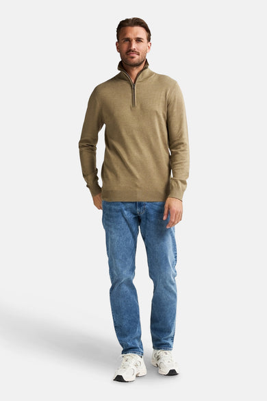 Pull beige à col rond de Petrol Industries, porté avec un jean bleu et des baskets blanches.