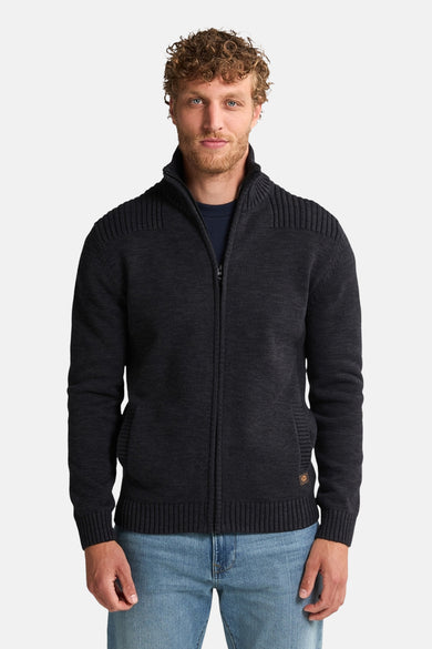 Zwart gilet van Petrol Industries, met ritssluiting en ribbelstructuur op de schouders, gecombineerd met een blauwe jeans.
