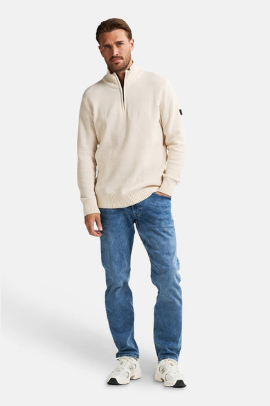 Gilet beige avec col rond de Petrol Industries, avec une fermeture à glissière et porté port jeans et des baskets.