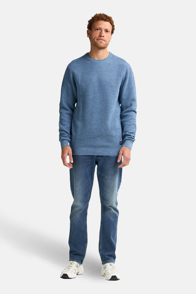 Blauwe trui met ronde hals van Petrol Industries®, met lange mouwen, gedragen met jeans en sneakers.
