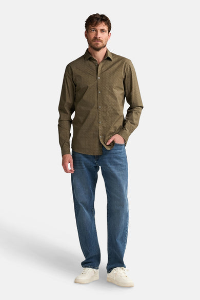 Chemise verte à longues manches de Petrol Industries, avec un motif subtil, associée à des jeans bleus et des baskets blanches.