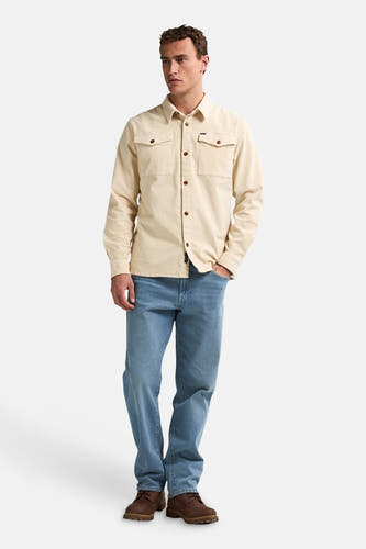 Beige overhemd met lange mouwen van Petrol Industries, met borstzakken en gecombineerd met jeans en bruine schoenen.