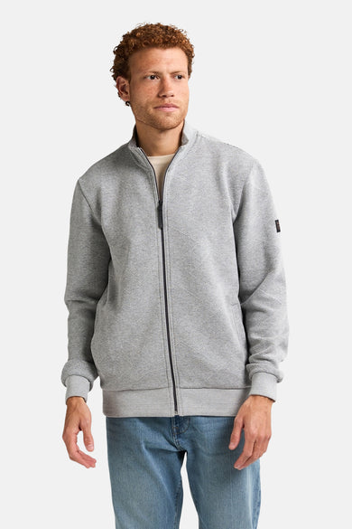 Veste grise de Petrol Industries® avec fermeture éclair et motif subtil, portée avec des jeans bleus.