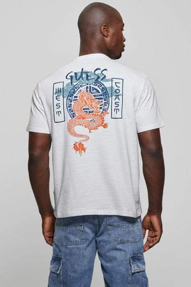 Wit T-shirt met korte mouwen van Guess® met oranje draak en blauwe 'Guess West Coast' rugprint, gedragen door een man.