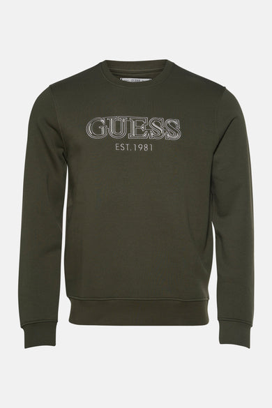 Groene sweater van Guess, met witte opdruk van de merknaam en het oprichtingsjaar.
