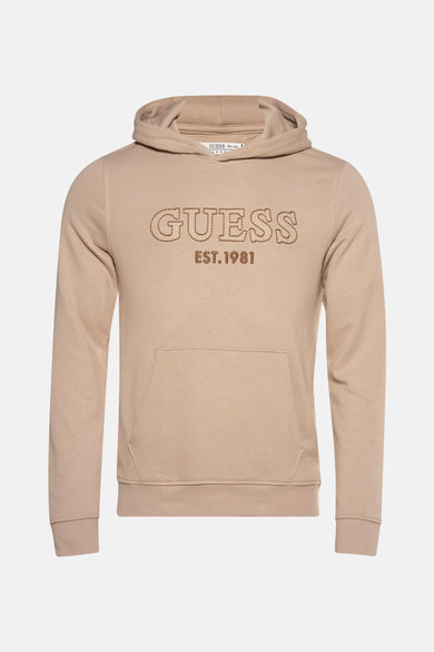 Beige sweater met kap van Guess met een logo en “EST.1981” erop.