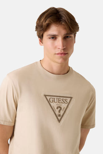 Beige T-shirt met korte mouwen van Guess, met een logo print op de borst.