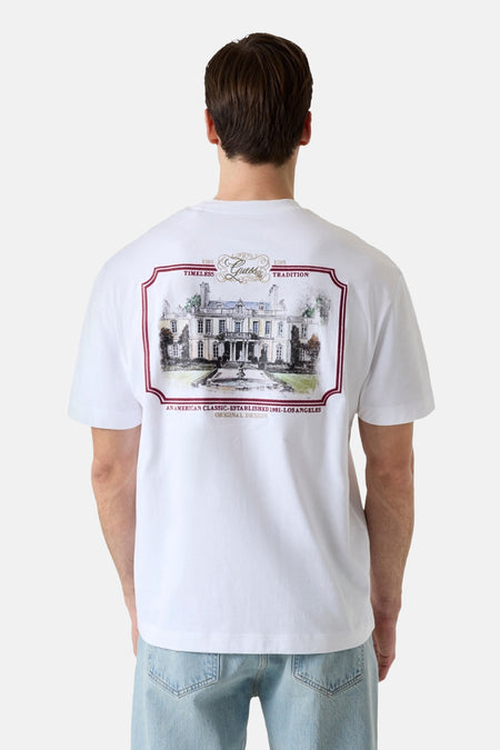 Witte korte mouwen T-shirt van Guess® met groot achterprint van een herenhuis in rode lijn, gedragen van achteren.