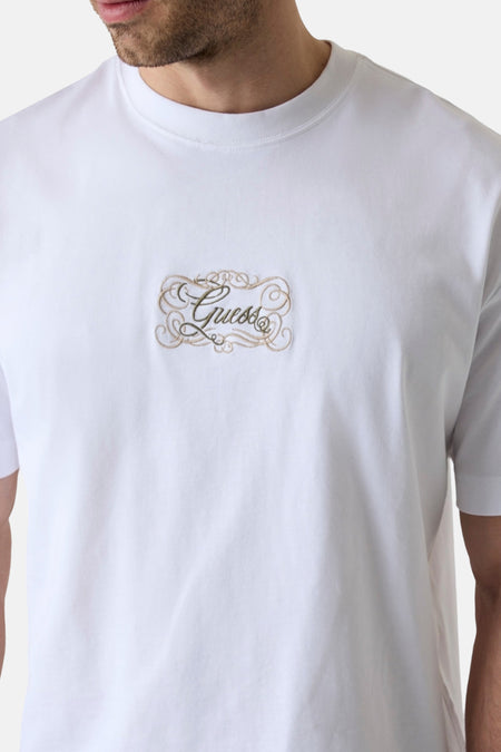 Witte korte mouwen t-shirt van Guess® met goudkleurig borduursel op borst, close-up voorzijde