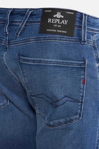 Slim fit jeans van blauw denim van Replay, met achterzak en rode details.
