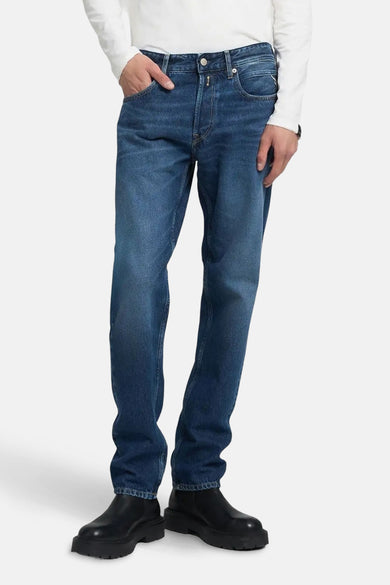 Blauwe straight jeans van REPLAY, gecombineerd met een wit shirt en zwarte schoenen.