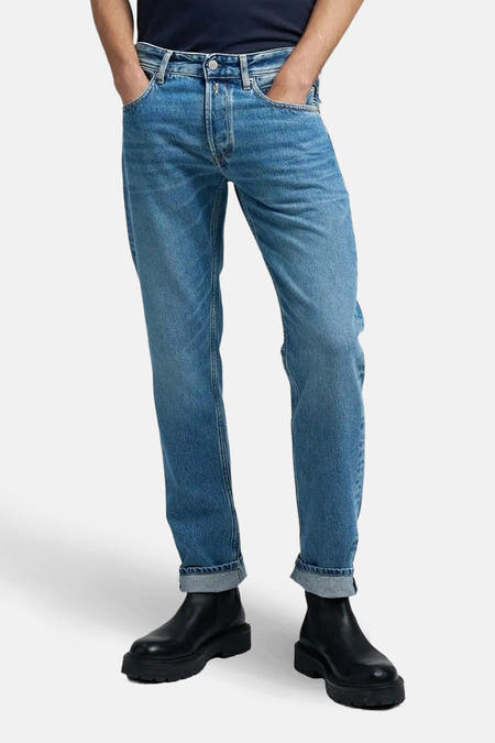Middenblauwe straight jeans van REPLAY, met omgeslagen pijpen en gecombineerd met zwarte boots.
