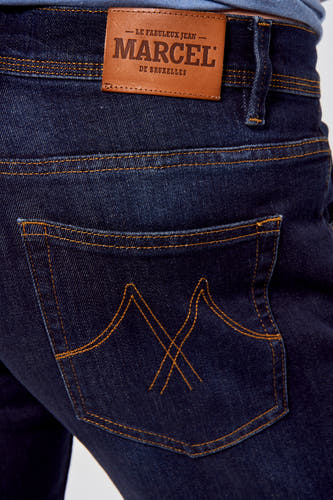 Jean slim fit bleu marine de Le Fabuleux Marcel de Bruxelles, avec des surpiqures brunes et une étiquette en cuir.