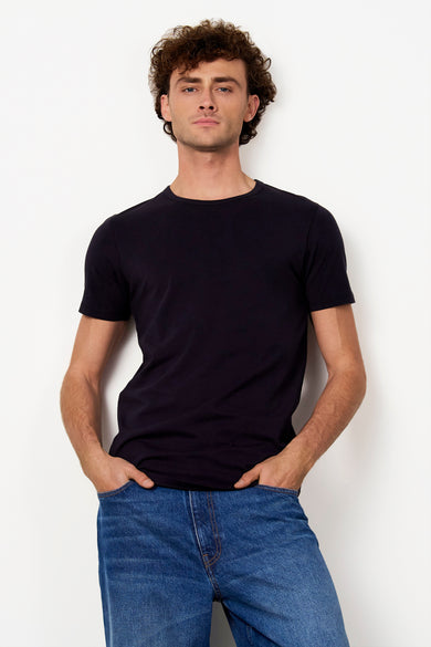 T-shirt noir de Le Fabuleux Marcel de Bruxelles, porté avec un jean bleu.