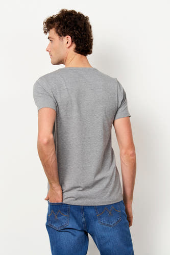 Grijs T-shirt van Le Fabuleux Marcel de Bruxelles, gezien vanaf de achterkant, gedragen door een man in spijkerbroek.
