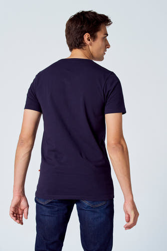 Blauw T-shirt van Le Fabuleux Marcel de Bruxelles, met korte mouwen, rugzijde gezien, gecombineerd met een donkere jeans.
