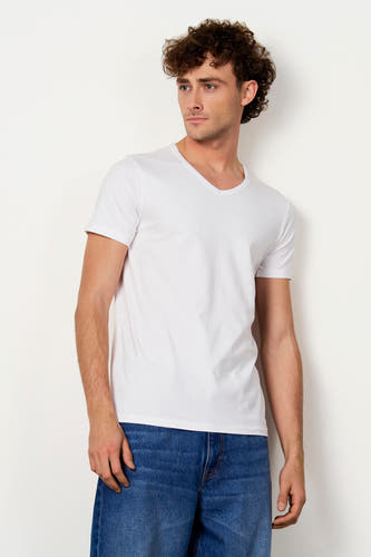 Wit T-shirt van Le Fabuleux Marcel de Bruxelles met V-hals, gedragen door een man in spijkerbroek.