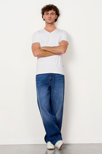 Wit T-shirt van Le Fabuleux Marcel de Bruxelles met V-hals en korte mouwen, gedragen door een man met gekruiste armen en jeans.