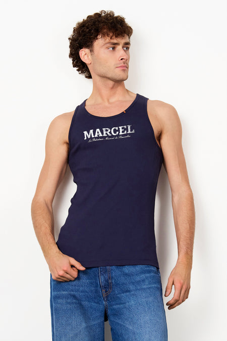 Débardeur côtelé bleu de Le Fabuleux Marcel de Bruxelles avec inscription blanche 'MARCEL' sur la poitrine et détail de drapeau à l'encolure.